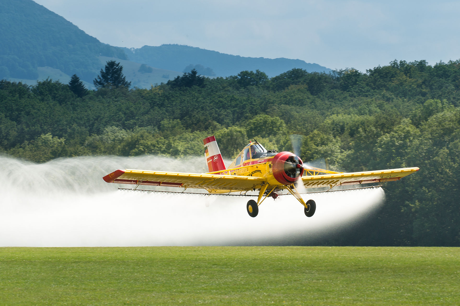 crop duster spraying insecticide on field