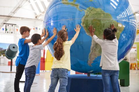 children holding up plastic globe