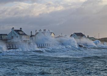 Waves crashing over houses